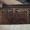 Basic Checkbook
Original by Joni
Item SOLD    CAN REMAKE
Dragon surqounded by Celtic scrolls, Fillagee cut outs with sparkle background in scrolls.
Shades of brown, yellowish cream, red, 
Room for initials or concho of sword, crossed ax, dragon, initials or celtic knot, or pitsh.   $7.00 more