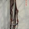 New 5/8" Bridle, Bit & Reins Combo
 Item # Bridle 6 
$36.00 plus shipping
Horse's Right ear Head stall.
Quality red latigo bridle combo.
Everything attaches with thongs.
Cheek pieces and throat latch attach with a square buckle. Curb bit. chin strap.

A few imperfections by crease mark on reins.